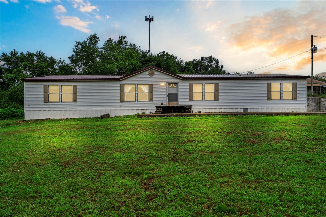 BACK ON THE MARKET & PRICED TO SELL! Previously appraised at $300,000 and now offered at $290,000. Situated on approximately 6.45 acres, this property offers space, privacy and plenty of opportunity to make it your own. With two parcels included in the sale, there’s room to enjoy country living while still having convenient access to Northwest Arkansas amenities. Property is being sold AS-IS. Don’t miss the opportunity to own over 6 acres at a price below its previous appraised value! The spacious 4 bed, 2 bath double-wide features two living areas and plenty of room to stretch out. An outbuilding provides extra storage, and the inoperable chicken houses (since 2019) offer repurposing potential. New roof in 2024 and HVAC replaced in 2011. Whether you're dreaming of a mini farm, a peaceful retreat, or building new, this land is full of opportunity.