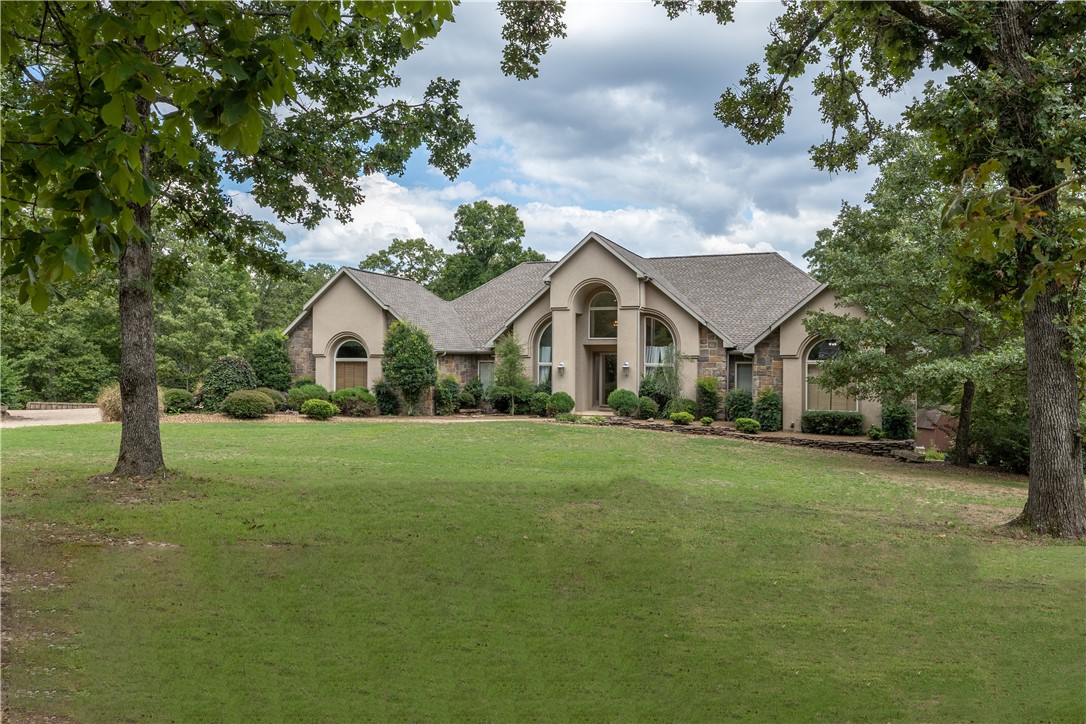 Welcome home to your 1 Owner, Custom built retreat thoughtfully placed amongst  7+ acres of all the beauty & hardwoods the Ozarks have to offer.  Quietly placed at the end of a cul-de-sac street ensuring premium privacy & guaranteed relaxation.
Yet this home, located in Highlands Estates, is only 2 miles to I-49 & approx. 5 minutes to 18 holes of championship golf like Highlands & Scottsdale Country Clubs.  Is the lake life your game ?  Loch Lomond, the largest private lake in All of NWA is just a few minutes away as well. And if you haven’t heard, Bella Vista is now home to one of the top mountain biking trail systems in the entire U.S.  And, you can be on these nationally renowned trails, in mere minutes.
Home boasts over 7,000 heated sq ft, thanks to the radiant heating system in the 2500 sq ft shop.  This custom building has it’s own RV bay plus the capacity to fit 6 MORE CARS as well. Wow!  This shop has so much potential for other uses as well. 4th BR getting closet remodel.