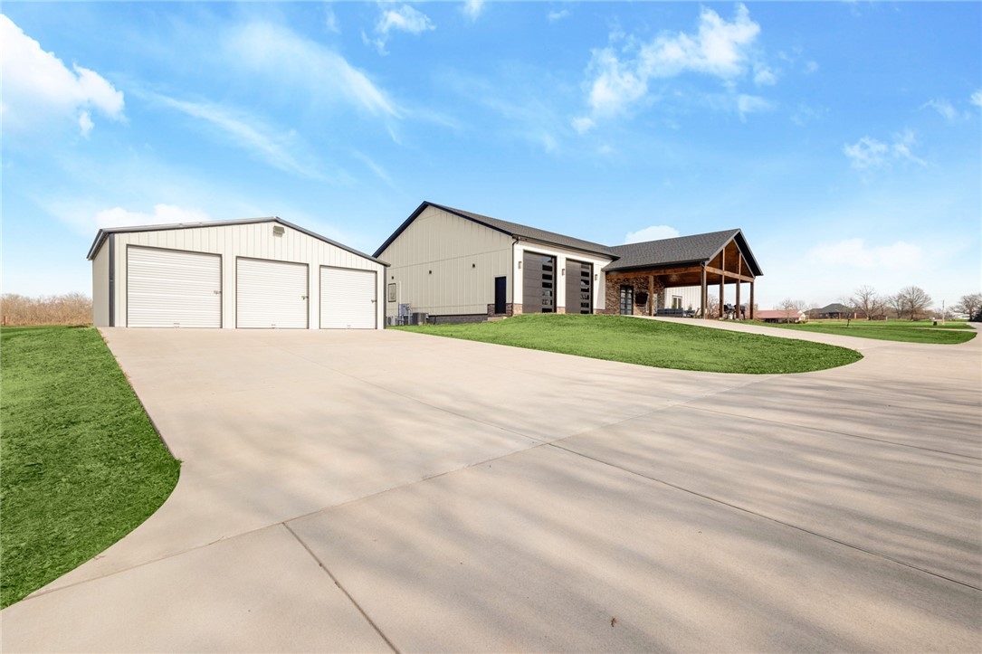 MUST SEE! Too many upgrades to list....Discover luxury living on 2.5 acres. This modern 4-bed, 2.5-bath home (built 2023) offers 2,750+ sqft of high-end comfort and thoughtful design. The chef’s kitchen features quartz counters, custom cabinetry, hidden pantry, smart storage, and Café appliances. A vaulted 16-ft living room showcases custom lighting, automatic blinds, and an elegant electric fireplace. The private primary suite includes a spa-like bath with freestanding tub, floating vanities, dual shower heads, and a boutique-style closet with built-ins. Guest rooms boast oversized closets and wood-tile flooring. A spacious bonus/media room with wet bar opens to the patio. Enjoy an attached epoxy-floored oversized, (heated + cooled) garage with EV charger plus a detached 3-stall garage/shop. Main garage has 14ft ceilings and 12ft garage doors. Foam insulation, zoned HVAC, central vac, smart lighting, and generator wiring complete this incredibly efficient, meticulously upgraded home.