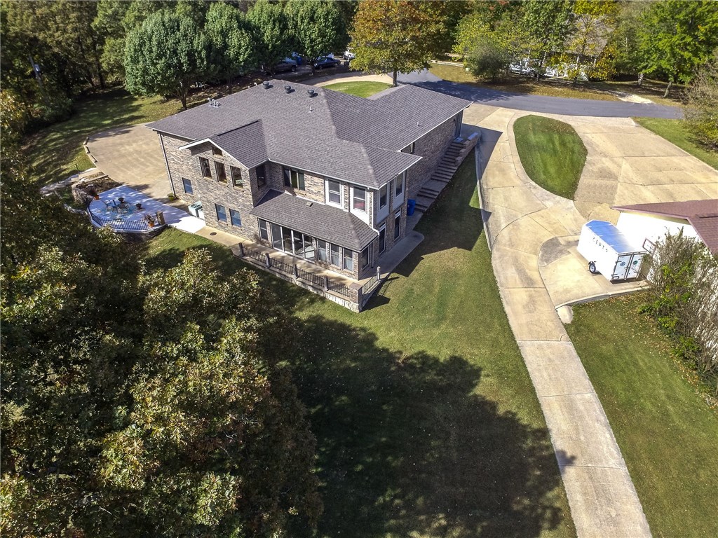Spacious custom built home on over 6 acres of land! Privacy and scenic settings with the convenience of being close to town. Easy access to I-49 with new 549 bypass. This property has ideal space for workshop or business with 31x70 shop with half bathroom, and 40x50 shop. Bright and open layout is great for entertaining. Large living room. Office space off living room. Huge kitchen with plenty of space for any home chef, featuring built-ins, island, and counter seating. Dining room is located off the kitchen. Finished basement provides a second living area that is perfect for home media and game room.Large outdoor patio is a great space for enjoying the wooded scenery and wildlife. Master bedroom has attached bath. Three additional bedrooms add plenty of space. This home is a must see!