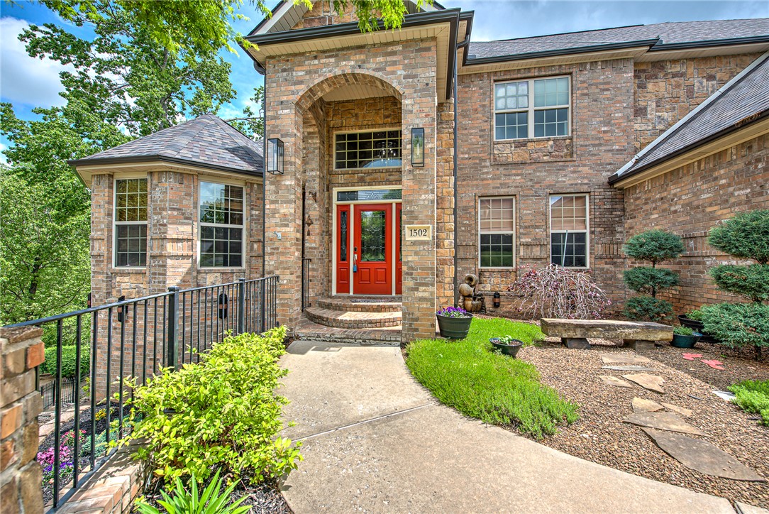 You’ll be swept away by this meticulously maintained 3-level home in the heart of Bentonville, where one beautiful room leads effortlessly to the next. This 6,000 sq ft beauty offers sweeping treed views and 2 expansive levels of decking—ideal for entertaining! Inside, enjoy beaming solid wood floors, extensive crown molding, high ceilings, and thoughtfully designed spaces including a private study & a gracious formal dining room perfect for hosting. Multiple living areas showcase gorgeous picture windows that flood the home with natural light and scenic views. The open eat-in kitchen features double ovens, a gas cooktop, & pantry. The main-level primary suite is spacious, private, & offers beautiful views. The stunning lower level offers a large family rm, fireplace, wet bar, 2nd primary suite, and a gym/6th bedroom. Walk-in closets throughout, move-in-ready, an incredible neighborhood, & a prime location just minutes from vibrant downtown Bentonville complete this exceptional home!