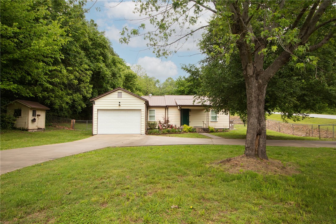 $2300 preferred lender credit with Stephanie Bevard at First Colony Mortgage. Updated and move-in ready!!! Major 2021 upgrades include upgraded electric, lighting, windows, HVAC, and a matching Whirlpool kitchen appliances. The interior boasts granite countertops, a kitchen island, tile backsplash, and wood vinyl plank flooring with tile in the dedicated laundry room. Modern touches include dimmable living room lighting, ceiling fans, OzarkGo high speed internet and a Nest thermostat. The primary suite offers a walk-in closet and tub/shower combo. Outside, the large yard is equipped with a storm shelter, a back shed, and a well house. Fayetteville Rural water is connected but it does have an unused private well. Vapor Barrier installed in crawl space in 2026. With all the updates throughout, this home is built for efficiency and low-maintenance living. Perfect for a first time buyer!