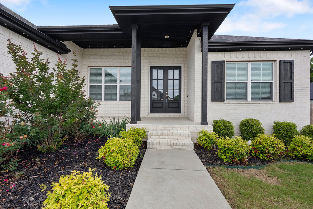 Move-in ready on a spacious corner lot! From the moment you step on the covered front porch, through the beautiful double doors, and into the welcoming foyer, you know you’re going to love this floor plan! The open-concept layout offers split bedrooms, a dedicated office, and a private primary suite with convenient access directly to the laundry room. The spacious living room is filled with natural light & features a beamed cathedral ceiling, gas-log fireplace, custom built-ins, & stylish open shelving. The kitchen is complete with quartz countertops, pantry, gas cooktop, & an eat-at island with room for 4.  The dedicated office with French doors and a closet offers flexibility as a 4th bedroom, playroom, or hobby space. Hate carrying items up janky stairs to the attic?Check out the remote control Versa Lift!  Best of all — zero carpet throughout the home and a 3-car garage! Step outside to enjoy the covered back porch overlooking the large fenced backyard. Community pool, trail, and clubhouse!