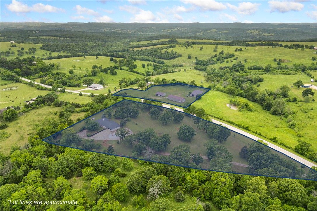 Near Bull Shoals Lake, this unique 12.5-acre property offers an incredible opportunity for a private retreat, full-time residence, or weekend lake escape. The property features a one-of-a-kind 6 bed, 4 bath home with approximately 3,000 sq ft on the main level plus an additional 2,500 sq ft basement, offering plenty of space for entertaining, guests, or flexible living arrangements. Large mature trees, inviting patio spaces, & peaceful Ozarks surroundings create the perfect setting to relax after a day on the lake. Also included, across the street, is an approx. 100’ x 40’ heated & cooled shop building with electric, water, sewer, 16-foot sidewalls, three 14-foot doors, a 10k lb car lift, & existing bathrooms. Two additional large buildings provide even more storage & versatility. Local lore says Ellie May Clampett once lived here, adding unforgettable character to this remarkable property. This property is also listed separately, with the house in MLS#1346828 and the shops/outbuildings in MLS#1337833.