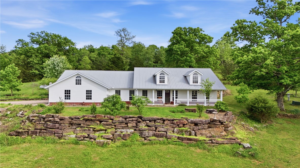 Absolutely gorgeous views of the Ozark Mountains, this 21 acre property offers a 2,550 sqft main home and an 1,800 sqft insulated shop with electricity, water, kitchen, bathroom, and heat/air. Walk into the main home's soaring vaulted ceilings, a massive primary suite, and a flex room that could serve as a home office. Hobbyists and mechanics will fall in love with the 30x60 insulated shop that has a 10,000lb vehicle lift - it's a dream workspace with phenomenal versatility. Outside, the land is a true sanctuary. Raise livestock, drop a fishing line, or simply enjoy the peace and quiet the two pristine ponds deliver. Explore the many hand-cut trails that weave through the property or explore the beautiful creek and waterfalls running along the north side of the property. Abundant wildlife will keep you company year-round. Only a mile away from Brentwood Community Park, where you can swim, fish, or relax on the banks of the White River. Being Sold AS-IS. Mobile home is not livable and is used for storage.