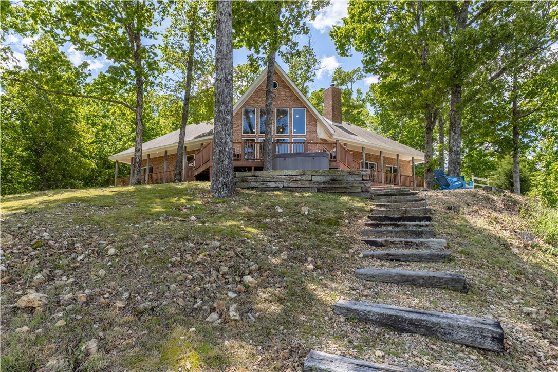 Imagine waking up every morning to panoramic views of Beaver Lake from every room in your home — then checking your VRBO income while guests enjoy the same experience. This fully furnished, off-grid-capable lakefront retreat sits on 9.3 secluded acres with 750 feet of private shoreline, making it one of NW Arkansas's most compelling live-in or investment properties. The custom-built home features soaring 14-foot cathedral ceilings, granite counters, and a split floor plan where all three bedrooms open directly onto a sweeping deck above the water. An 8-person sauna, hot tub, and fire pit keep guests coming back — and the reviews show it. With owned solar panels, a private well, and battery storage, your overhead stays low while your rental appeal stays high. Additional building sites offer room to expand with cabins or a shop. Whether you're seeking a legacy property, a high-performing short-term rental, or both — this estate delivers.