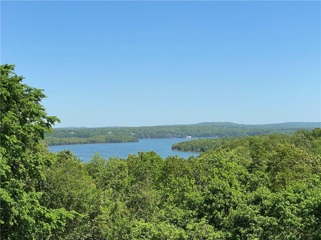 Optimized for privacy and breathtaking year-round Beaver Lake views from almost every room! Freshly painted 960 sq. ft. covered upper deck with hot tub and 775 sq. ft. covered lower deck.  2 minutes from the Beaver Lake beach and boat ramp. 8 minutes to Prairie Creek marina. Updated and gorgeous home with sizeable rooms and a logical flow layout.  Each level has its own master bedroom suite, family room, and wet bar!  Spacious kitchen with a stunning lake view, additional large bedrooms, weight/theatre room, and an expansive laundry/pantry/mudroom.  The home is built on a solid concrete foundation and has an enormous 4-car garage.  Updates include: a new roof, new appliances, moldings, all-new paint, hardware, light fixtures, new garage doors, new gutters with leaf screens, professional landscaping, and the list goes on!