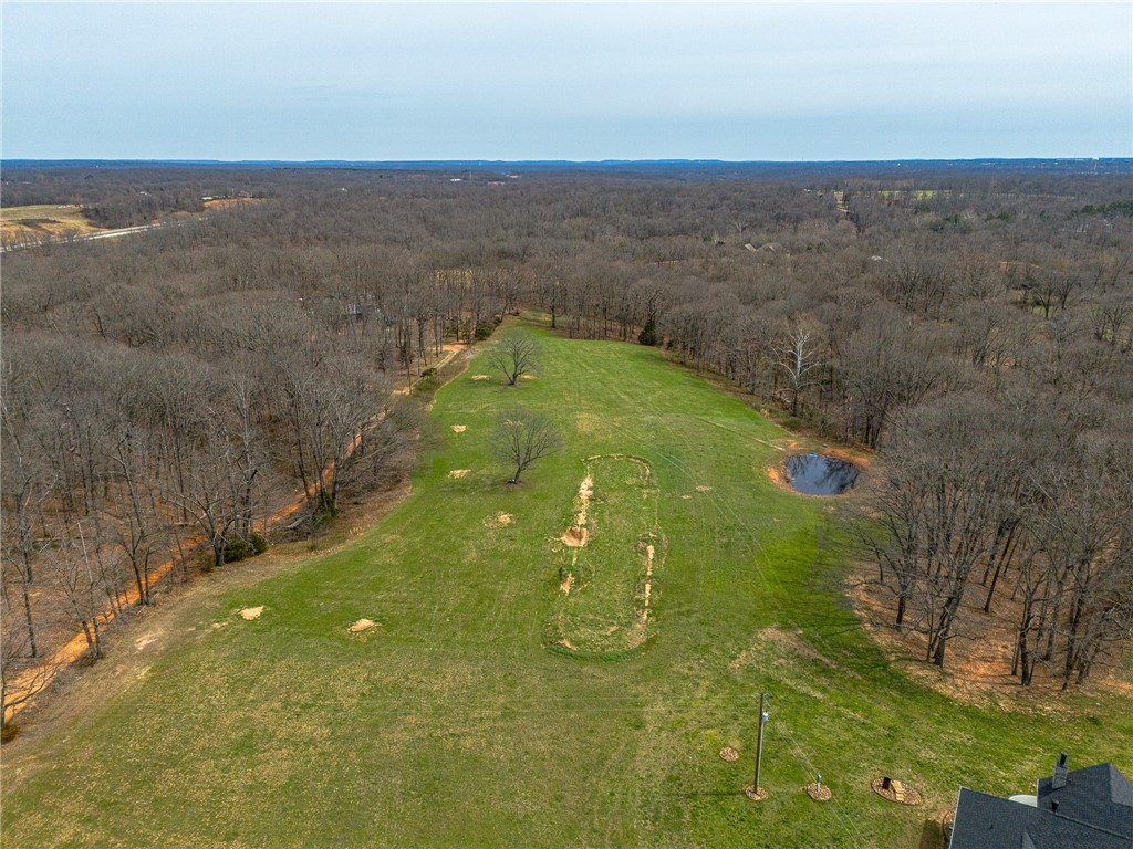 This elevated, flat, fully cleared and level 8.47-acre parcel offers strong development potential and is ideal for a beautiful custom dream home with shop or multiple residences. Located in the highly desirable Bentonville School District with Bentonville West High School just 2 miles away. The property sits directly off Hwy 72 with excellent access, visibility, and county road frontage (partially fenced on three sides). Conveniently positioned only 7 miles from downtown Bentonville and the Walmart campus, and just 2 miles from I-49 and local biking trails. Water and electric are available at the street, septic design is ready, making this rare flat high-ground site build-ready. Parcel #18-09659-003