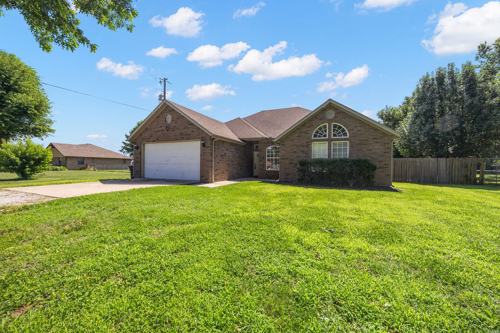 Want that country feel close to everything? This one-level, all-brick home on 0.60 acres is for you! Nestled in nature yet just a short drive to Bentonville or Fayetteville, this beautiful 1,703 sq ft, 3-bed, 2-bath home has it all. You'll love the spacious living room with its cozy gas fireplace. The chef's kitchen is built for entertaining with an oversized island, ample cabinet/counter space, and a pantry. The oversized dining area lets in tons of natural light with plenty of room for a large table. Step outside to the covered back patio to sip morning coffee and take in your expansive yard with a view. Inside, the split floor plan offers a roomy primary suite with a freshly painted bath and large closet. The front guest bedroom features a vaulted ceiling—ideal for a home office.  The full guest bathroom has been freshly painted as well.  This is a dream home if you want room to roam. See it and make it yours today before it’s gone!