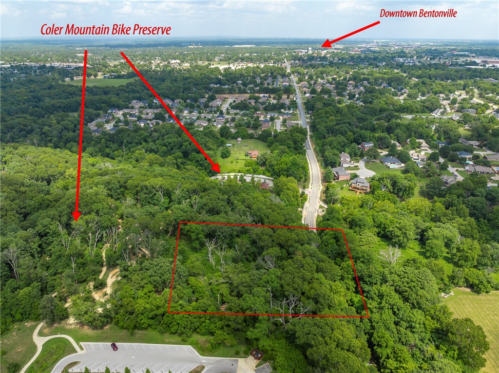 A truly rare opportunity to own approximately 4 acres surrounded on three sides by Coler Mountain Bike Preserve—one of Bentonville’s most iconic outdoor destinations. Located on 3rd Street just above the lower trail parking and adjacent to the upper lot, this property offers an incredible setting for a private estate or the potential to divide into two or three homesites and create your own enclave with family or friends. Step outside and experience the Bentonville lifestyle with world-class mountain biking, walking and running trails practically at your doorstep. Ride or walk through Coler to Airship Coffee, tackle the 185 steps of The Rise, or head into Downtown Bentonville in less than a 7-minute bike ride. Enjoy the feeling of being surrounded by nature while remaining minutes from everything downtown has to offer.