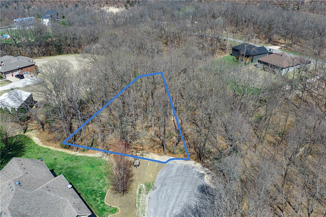 Tucked at the end of a peaceful cul-de-sac on Askew Lane, this 0.24-acre wooded lot in Bella Vista's Croydon subdivision is your chance to build something special. The gently sloping, tree-lined terrain provides privacy and natural charm at an incredibly accessible price — just $19,000 with annual taxes of only $53. Electricity runs to the street, public water is available, and a private septic system will be needed. As a Bella Vista POA member at just $16/month, you'll enjoy an extraordinary lifestyle: 7 golf courses, 7 private stocked lakes, 100+ miles of hiking and biking trails, swimming pools, tennis courts, fitness centers, a gun range, and parks throughout the community. This is NW Arkansas living at its finest.