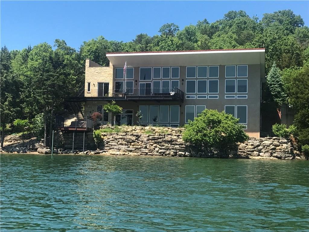 Lake Front Home with no trees on Corps line, 1 slip in brand new community dock.  Hugh lake views, windows from floor to ceiling with ceiling height around 11 foot on both floors. Outdoor kitchen with 220v and 110v with water and drain.  Private boat ramp to beaver lake.  Handicap designed, oversized garage for cars and UTV's.  Front of house has trailer hook up with all utilities'.   Lots of concrete around the property.  Beautifully designed inside with Austin Stone. If you like the pictures make appointment
