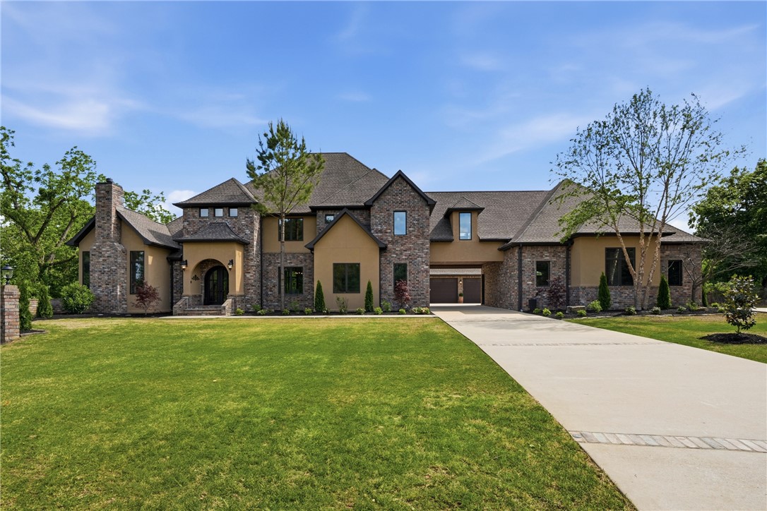Located at the end of a private driveway, this luxury estate in Talamore sits on 2 large lots totaling 6.5 acres. Surrounded by trees and adjoining the neighborhood pond, there's a strong feeling of seclusion. Inside you'll find elegance, from the wood floors and trim to large windows and sleek, modern design. The spacious layout includes a large living area, office, 5 bedrooms, flex space, and a gorgeous kitchen- thoughtfully designed with a spacious island, dual pantries, and an array of high-end appliances. Unwind in the primary ensuite in the oversized soaking tub and custom dual entry tiled shower. Outdoors, you'll find pristine manicured landscaping, heated saltwater pool, pool house, and outdoor kitchen ideal for entertaining. The home also includes 3 garage spaces, and an additional heated/cooled bay converted to living space and 1/2 bath. State-of-the-art camera system and whole-home generator add peace of mind. Just slightly over 5 miles to the Bentonville square, this is luxury living at its best.