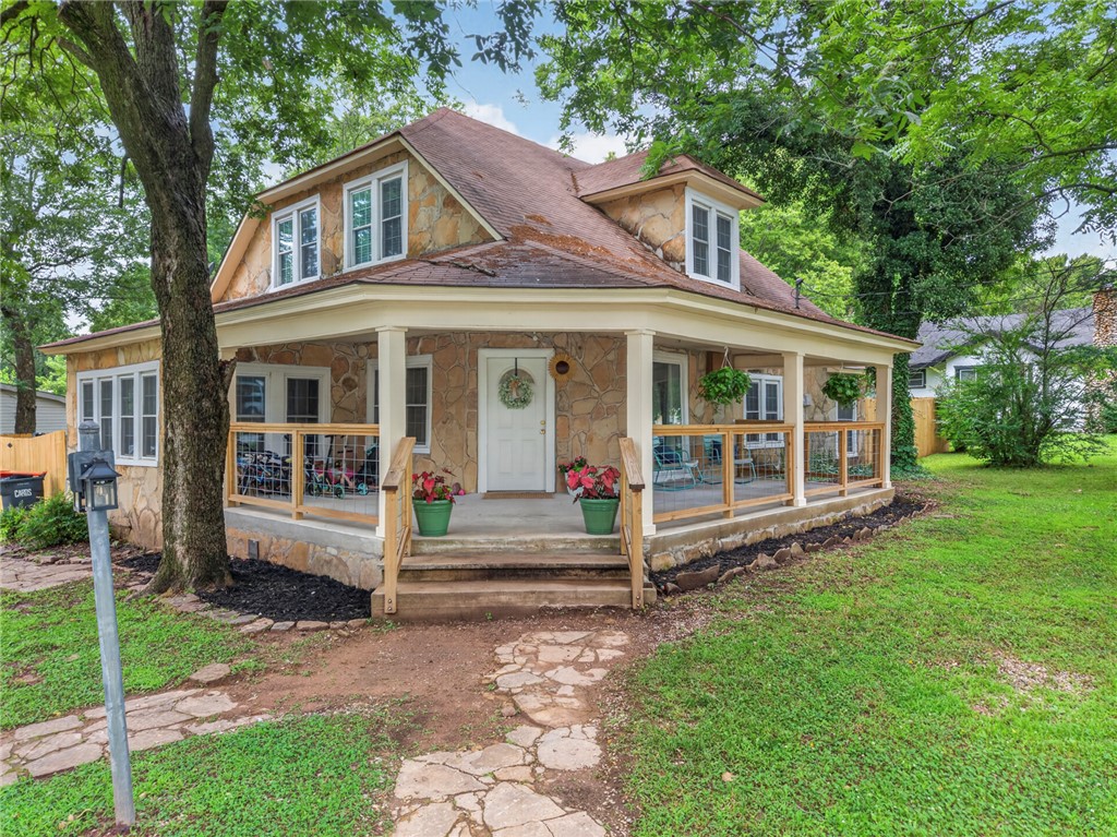 Welcome home to your gorgeous own storybook fairy tale stone house on a large corner lot. This 4 bed 1 full bath offer 2,235 sq/ft with plenty of space for gatherings and your enjoyment. Interior features newer paint and flooring throughout most of the house done in 2025. As well as new fixtures. blinds, and an updated bathroom with new faucets, fixtures, paint, and mirrors. New updated plumbing 2025 from the house to the main line at the road plus added a clean out at the house which is a (7K) value in upgrades for plumbing alone. Additional (5-7K) in new flooring and paint. The exterior features a stunning wrap around porch for sipping your coffee and enjoying rainy days. Here you have the best of both worlds, small town charm with the convenience of being close to NWA for all amenities, shopping, and restaurants. Only 2 mins from a Harps grocery store at this wonderful location. Schedule your tour today. This home is ready to be your home sweet home.