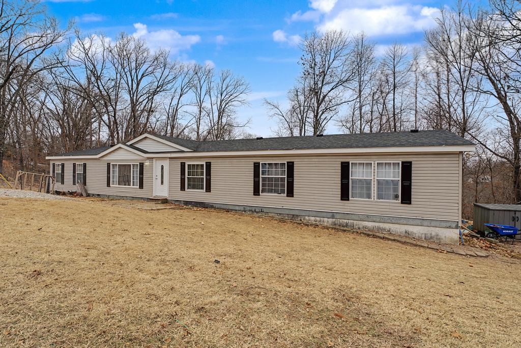 Come check out this well-kept, updated manufactured home with a permanent foundation sitting on 3 quarter acre lots in Bella Vista! Conveniently located just 10 minutes to the bike park, 6 minutes to Tanyard creek, and a 15 minute drive to Mercy and I-49! This 2,280 square foot home features a functional split floor plan, open kitchen and dining area, built in desk and storage, and a large bonus room with a wood-burning fire place great for a second living space, home office, or game room! Current owners added a fresh coat of paint and new flooring through out, painted cabinets, updated shower in primary suite, new deck and cleared yard + 17 trees. The roof was replaced by previous owners in 2016 along with the range (2021) and dishwasher(2022). Detached storage unit conveys. No POA!