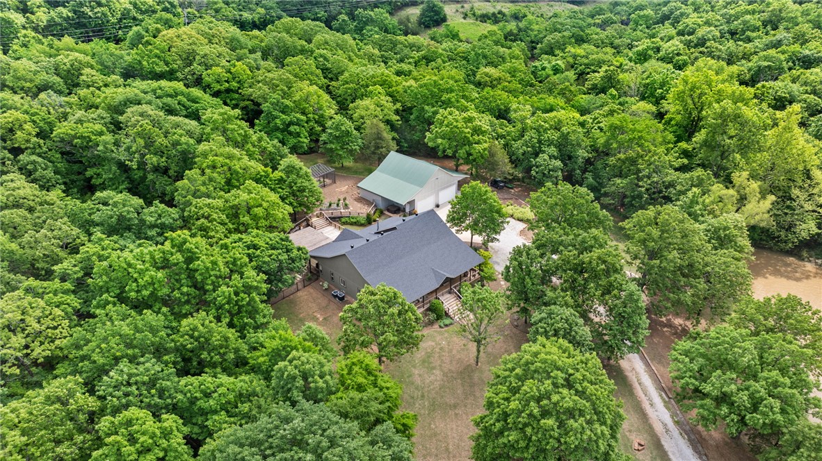 This isn't just a house, this property is a lifestyle. Escape to your own private retreat. This stunning home was completely remodeled starting in 2017. One hundred year old refurbished wood floors and barn beams were brought in during the remodel. The home is nestled privately among the trees and surrounded by nature but still is open to a beautiful private view. The property features a large, well-stocked pond - ideal for an afternoon of fishing or sitting on the overlook by the fire. The spacious shop is equipped with a wood burning stove, lots of cabinets and wired for TV.  Property offers a beautiful fenced backyard with custom built garden house along with raised beds, a large layered deck that is great for entertaining with lots of options for seating arrangements, a pergola covered cook area, and lots of wildlife to watch. Professionally installed landscaping is complete with irrigation. House is equipped with a backup 400 gallon storage tanks approved for drinking water along with a whole house generator.