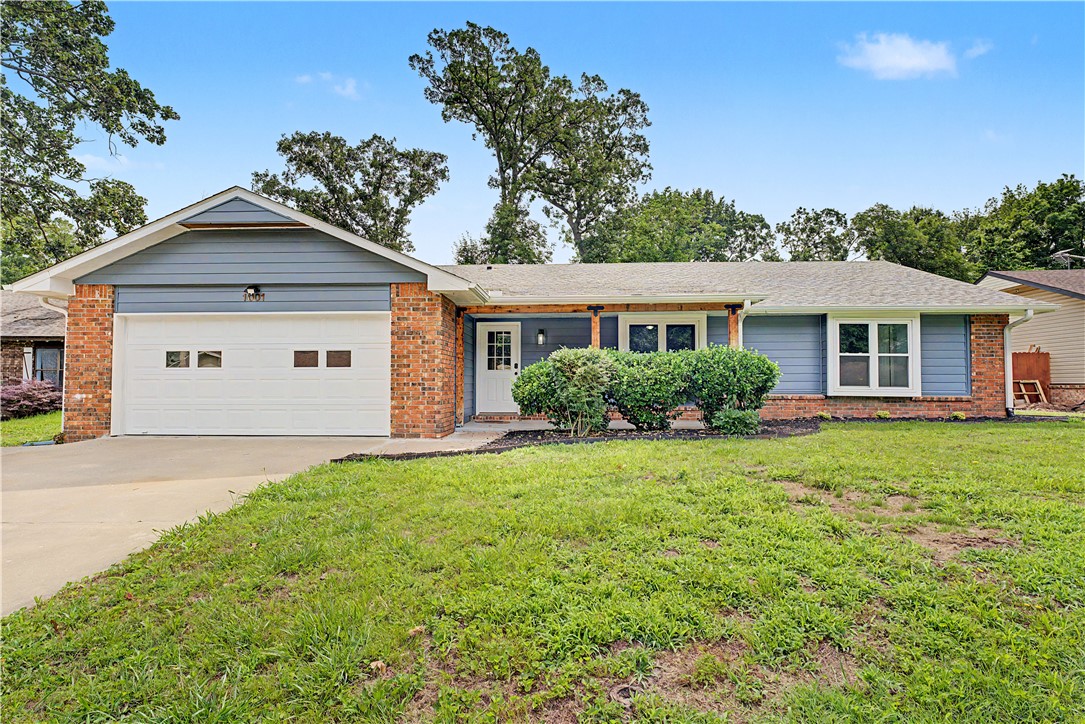 Located in the sought-after Whispering Timbers subdivision, this well-maintained 3-bedroom, 2-bath home blends comfort, updates, and convenience. Set on a spacious, tree-shaded lot with a fenced backyard, it offers privacy and outdoor living space. Inside features an open layout with vaulted ceilings, fireplace, and abundant natural light. Recent updates include new flooring a  refreshed primary bathroom enhancing move-in readiness. The functional floor plan includes an eat-in kitchen, formal dining, and private primary suite with walk-in closet. A covered patio extends living outdoors. Just minutes to I-49, Walmart headquarters, shopping, dining, and entertainment, this Rogers location delivers both neighborhood charm and everyday convenience.