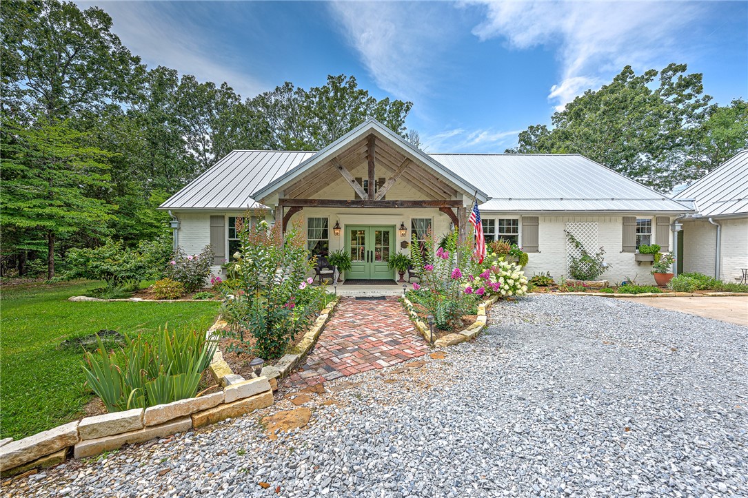 Discover your serene 21-acre French Country Oasis! Embrace the tranquil woods and lush gardens surrounding the 2196 sq ft main house, plus an additional separate guest suite (465ft) connected by a breezeway to the garage. Bask in the bright open floor plan, adorned with Egyptian sconces and antique corbels from a St Louis' bank. The great room's vaulted wood ceilings flow gracefully to the chef's kitchen, boasting quartz countertops and a delightful dining area with a walk-in pantry and coffee bar. The split floor plan houses 3 charming bedrooms. Entertain with ease on the welcoming front porch or the spacious vaulted rear screened-in porch with a fireplace, where you can relish the soothing water fountain sounds and the sight of hummingbirds. Washer/dryer, fountain, water purification/softener are all included. Enjoy your very own private shooting range and compost areas.Masons Creek on the property.Opportunities like this do not come along often! This 2018 custom-built gem by Wayne Foster is your dream come true!