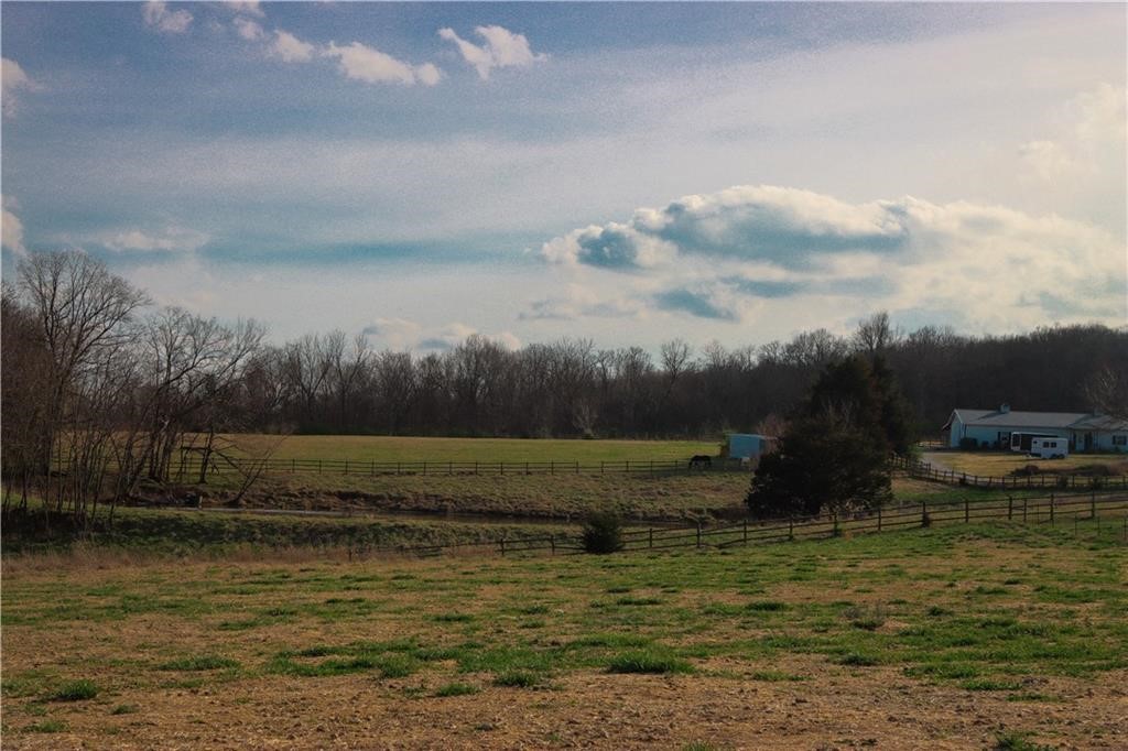 Fifteen acres in northeast Fayetteville!  Through the gated entry and down a paved 1/4 mile driveway, you will find fifteen beautiful acres just waiting to become the estate of your dreams.  This acreage offers improved, fenced pastures, shop and horse barn, large pond, some mature shade trees and very private estate sites.  Truly a one of a kind offering in an area of prestigious homes.  Can be used as an estate or divided into as small as three acre tracts.