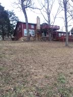 Unique Ozark remodeled home in a great setting overlooking year round Bear Creek. Beautiful beamed ceiling w/stone floor and fireplace. Large sun room w/ lots of windows overlooking fishable creek frontage. Nice decks and views. Good pasture for horses. Antique Stove/Oven and antique mirrors don't go with property.