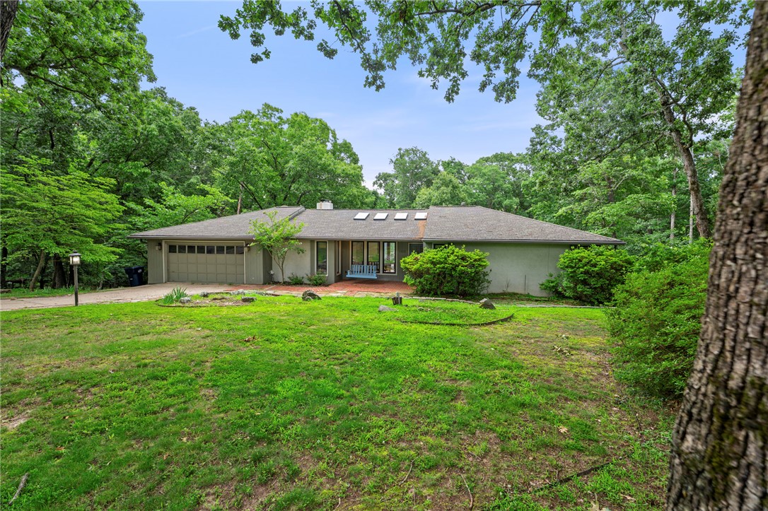 Tucked on a wooded 2+ acre setting just minutes from Downtown Rogers & Lake Atalanta, this one-of-a-kind retreat blends luxury amenities with character & story rarely found in today’s market. The expansive home unfolds through multiple living spaces including a primary living room, vaulted family room, flex space, sun nook, & game room. There's space & privacy for the whole family with 2 master suites, a built-in twin guest bedroom, and 4th bedroom with en suite bath. The kitchen anchors the home with a 48" 8-burner gas range with double oven, 5' SubZero fridge/freezer, abundant cabinetry, pantry storage, & wet bar. The raised deck overlooks the pool, stone patio, fire pit, & mature backyard trees. Walking through this property is an experience unto itself as you discover its built-in treasures like the stained glass details in the master and kitchen or the salvaged slate chalkboard floors in the basement. This home’s story has evolved over decades & is waiting for your next chapter to be written within its walls.
