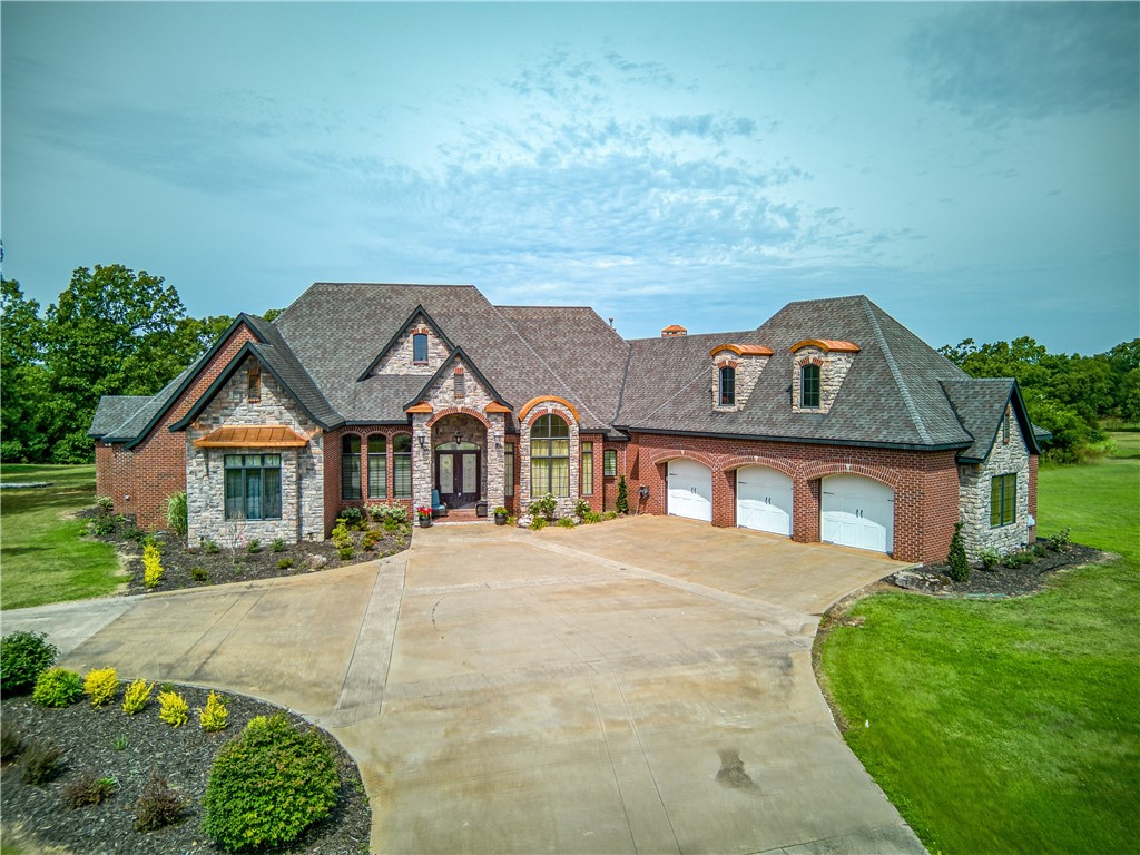 This could be your Dream home located on 25 acres of Pristine land that is surrounded by large trees, Picturesque Pond and has a 28x60 brick building that could be used as an additional 2-4 car garage and workshop or guest house. The external of the home exudes elegance with a tasteful combination of brick, stone, and copper awnings. The Interior boasts spacious rooms, large windows, 3 gas fireplaces, Cathedral and Barrel ceilings with crown molding throughout, Luxury wood and granite floors. 2 comfy living rooms, an office, an elegant formal dining room, a cozy breakfast nook, Gourmet Kitchen with high-end stainless steel appliances. granite countertops, pantry, and laundry room. On the main floor 2 beautiful master bedrooms with spa-like bathrooms that include jetted tubs, and walk-in showers. Upstairs features a large bedroom with a bathroom. attached is a 3 car garage. Seller will consider selling the 5.71 acre parcel seperately.
