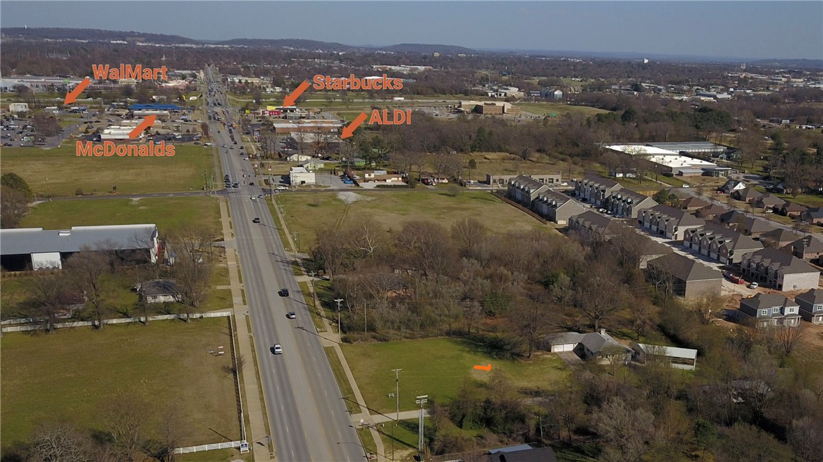 Investment and Develop Opportunity! This  3.02 commercial  zoned parcel sits right in a rapid growing area of Springdale. Commercial Road Frontage with strong traffic counts and exposure with proximity to I-49 is a fantastic  space and location for retail, strip mall, apartments, gas stations, warehouse, office space and more. On site 3240 Square Ft Home and Shop Structure on site -Ideal for office conversion or investment.  This property is only .4 miles from Walmart Super Center, McDonalds, Aldis, Starbucks and Mercy Emergency Hospital. Don't miss out on this great tract of commercial zoned land mostly cleared and ready for you to start your investment.