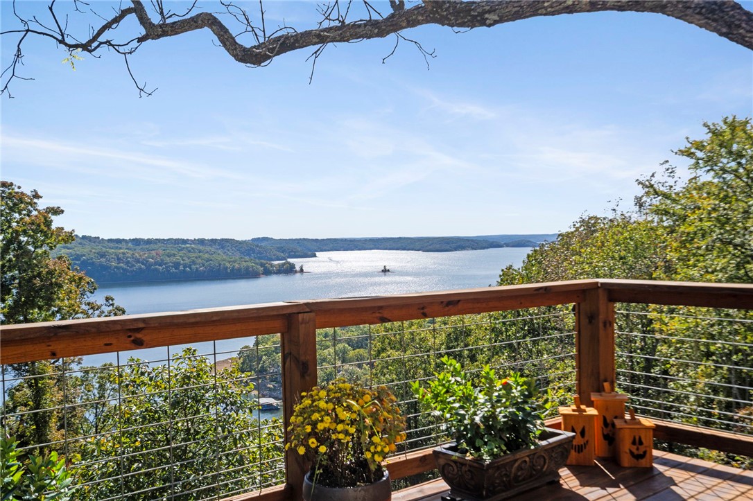 Experience the beauty of lake living in this stunning home overlooking the sparkling waters of Beaver Lake with private dock (11x30 slip). Designed to capture breathtaking views from every room, this property offers the perfect balance of comfort, style, & serenity. Step inside to a spacious open concept living areas, large windows flood the home with natural light, & a modern kitchen with high-end appliances & finishes, perfect for entertaining. The primary suite features a deck with panoramic lake views, creating a peaceful retreat after a long day on the water. Outside enjoy the expansive decks and outdoor living spaces, ideal for morning coffee or evening sunsets. With easy access to the lake, nearby Lost Bridge Marina, & miles of scenic shoreline...this home offers an ultimate lifestyle, most furniture will convey. A charming Casita completes this property, ideal for hosting visitors! Includes a gym, 2 bedrooms, & full bath. Large storage facility behind Casita for water toys. 2011 296 Cobalt boat will convey.