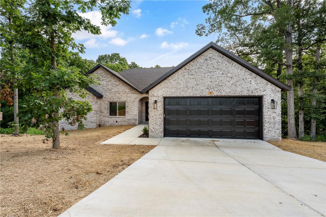 This beautiful new construction home is now complete and move-in ready! Nestled in the Highlands near Lake Loch Lomond, it offers convenient access to the bypass and is located within the Gravette School District. The thoughtfully designed split floor plan features 2 bedrooms, a dedicated office, and an oversized 2-car garage. The spacious living area showcases vaulted ceilings with wood beams and a stunning stacked-stone fireplace. There is wood flooring throughout the main living areas, hallway, and primary bedroom. The second bedroom and office have carpet flooring. The private primary suite offers a spa-like bath with dual vanities, a beautifully tiled walk-in shower with dual shower heads, a linen closet, and a separate toilet area for added privacy. The exterior features a brick front with vinyl siding on the sides and back. The spacious deck offers both covered and uncovered areas—perfect for relaxing or entertaining outdoors.
Please note: The septic system is designed for two-bedroom capacity.