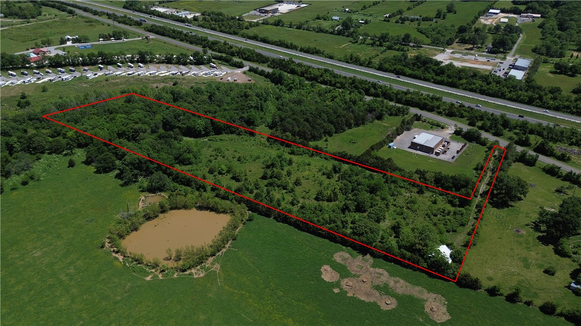 Rare 9.55-acre opportunity in South Fayetteville with interstate visibility, road frontage, and public water on site. Mostly flat with a mix of mature trees, open clearings, and a creek along the back of the property. Located in a rapidly growing corridor near existing commercial development including an RV park and office/commercial properties, offering strong future potential. Excellent access to I-49 and convenient proximity to both Fayetteville and West Fork.