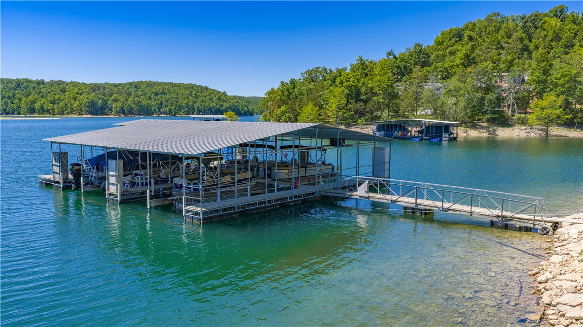 Motivated Seller!  See this outstanding lake home with a slip in the community dock & 4400 sq ft of living space including an enclosed heated swimming pool for year-round fun. Relax on the upper or lower deck & take in the fabulous lake view.  Updates include a new kitchen, primary suite & bath, and a huge patio for gatherings with family and friends.   Situated on 7.34 acres (divided into lots for possible future expansion) providing the luxury of peaceful privacy. The lower level with 2 bedrooms each with its own bath, a huge living area with seating, dining, & kitchen areas is perfect for large gatherings. The adjoining sunroom with hot tub will provide year-round relaxation & fun. Enhanced with newly painted interiors, rich new LVP flooring, & wonderful light filled rooms, you will love this updated home. Geothermal heating & cooling & there is covered parking with water & electric hookups for your RV. Located 1.5 miles from Rocky Branch Marina. Come home to 8250 Wills Court, Welcome!