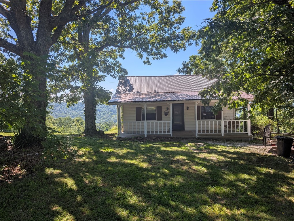 RUN! Don't WALK, to this adorable house with it's serene, peaceful setting and stunning mountainous views!  A "Cozy cottage" feel, with an inviting front porch swing.  This gem boasts 2 bedrooms, one bath, laundry room with built-in pantry area, walk-in closet in the primary bedroom, spacious Living and dining rooms. This property is framed with trees and forestry to aid in the secluded feel, while being close to all the small town amenities.  There is ample room for all your favorite outdoor hobbies, gardening projects, and activities. The basement has plenty of room for your yard equipment and workshop tools.  You might even convert it into a She Shed or Man Cave. There's even a chicken coupe for your feathered friends and an above ground pool for you to relax in while taking in all the beauty & nature around you.  Call for your showing today before this one gets away!!