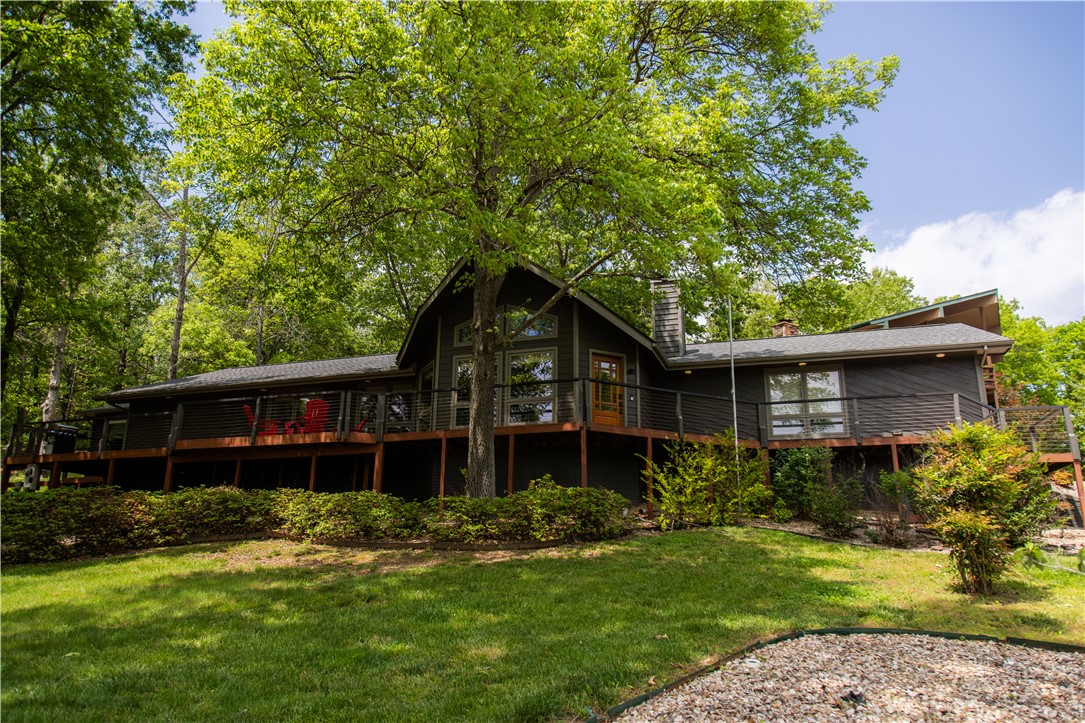 Welcome to a beautiful retreat moments from Lake Windsor offering stunning lake views and a peaceful natural setting. Designed to capture the beauty of its surroundings, the open-concept living area features cathedral ceilings with large windows that fill the space with natural light and frame the scenic landscape. The kitchen and dining area provide a comfortable space for everyday living and entertaining, while the expansive front deck extends the living space outdoors. A fire pit area creates an inviting setting for evenings under the stars. Additional features include a private indoor hot tub, offering a relaxing retreat year-round. Whether used as a primary residence, second home, or investment property, this home combines comfort and character in the highly sought after Mayfair subdivision. Enjoy the tranquility of lake living with convenient access to outdoor recreation such as the Tanyard Creek trails, golf courses, and renowned mountain biking trails. Home is permitted for a 2 bedroom septic system.
