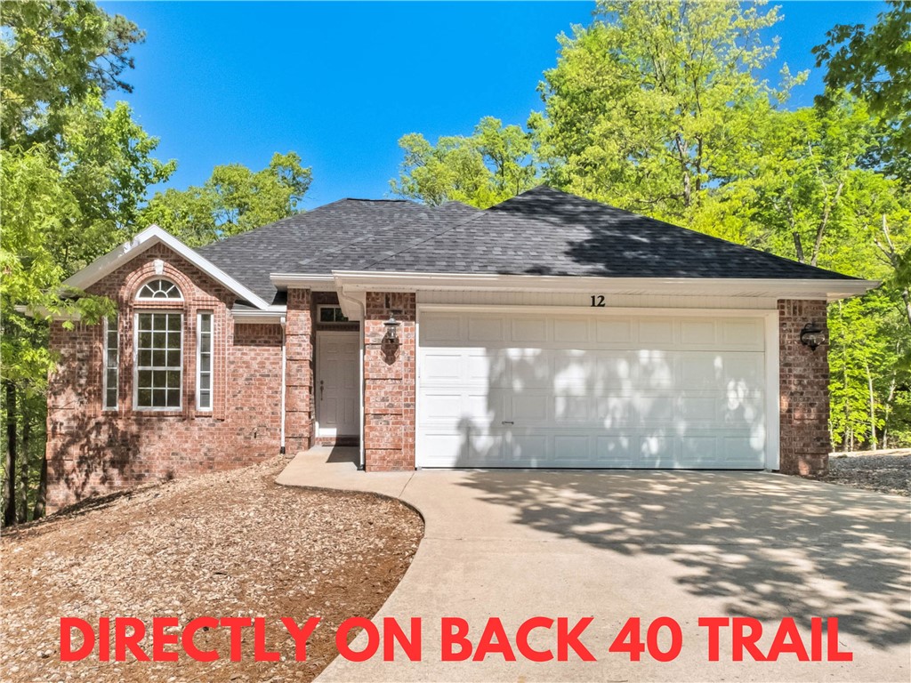 Well-maintained home on a wooded lot, offering direct access to the scenic Back 40 Trail and located within close proximity to Lake Ann, Lake Rayburn, and the OZ Bike Lift! This charming residence includes a new roof, new carpet, and fresh paint. The inviting open floor plan is perfect for gatherings, highlighted by a beautiful fireplace that adds warmth and character. Featuring 3 bedrooms and 2 bathrooms, the primary suite boasts elegant trey ceilings, while the guest bedroom features a stunning cathedral ceiling. Plus, you'll appreciate the abundant cabinets in the garage for all your storage needs. Washer, dryer, and fridge convey. Bentonville schools! Plus, take advantage of $3,000 in buyer's closing costs, courtesy of the seller's preferred lender.