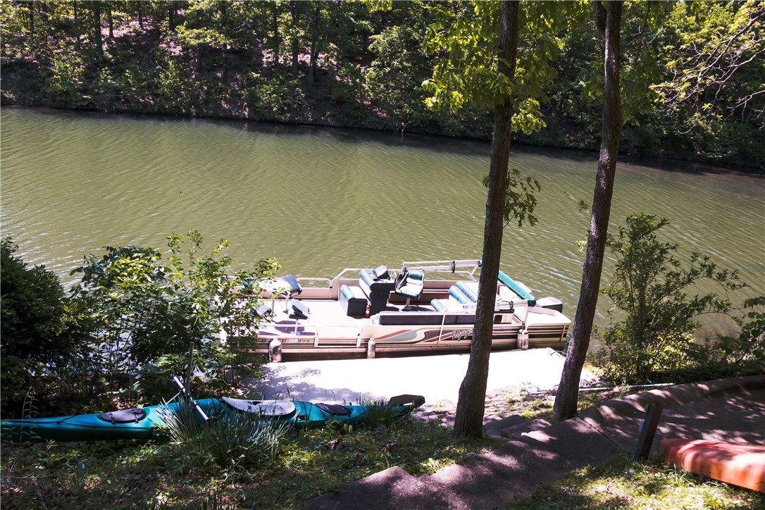 Secluded lake front living at its best! Newly remodeled lake home featuring 2 master suites, new back deck, Pergo flooring, fresh paint throughout, under mount sinks  & newly remodeled kitchen (i.e cabinets, granite, backsplash, and stainless steel appliances). The home has gradual walking path to dock or you take the cart path down to the water! New roof and fireplace insert in 2015! Hot tub coveys and Pontoon boat is negotiable! The property is also offering a 12 month warranty with acceptable offer!