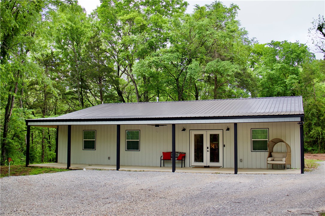 Midwest Land Group is proud to present this eye-catching country home on 3.39 +/- acres! From the moment you arrive, you’ll appreciate the peaceful, small-town setting surrounded by mature hardwoods and cedar, with a creek adding to the charm. This 3 bed, 2 bath home offers a split floor plan and spacious open-concept living area. The oversized island is perfect for gathering and entertaining, while the generously sized primary suite features a custom-finished en suite bath.

Built with quality and efficiency in mind, the home includes 2x6 exterior walls, open-cell spray foam insulation, and waterproof flooring throughout. The kitchen showcases custom hickory cabinetry and granite countertops, blending durability with style. A 50’ x 10’ covered front porch stretches the length of the home and is ideal for morning coffee or relaxing evenings.

With a low-maintenance exterior and high-end finishes, this property offers comfort, function, and room to grow—just minutes from Elkins.