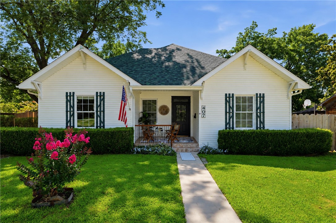 Step into a rare piece of Bentonville history, located in the Historic District less than two minutes from Downtown Bentonville Square. Originally established in the 1910's, this home has witnessed Prohibition, world wars, & Bentonville's incredible growth. Inside you'll find LVP flooring, custom crown molding, solid wood doors, shiplap walls, 10' ceilings, & a beautiful soapstone wood-burning stove set on bricks from the home's original fireplace. The custom kitchen features handcrafted wood cabinetry, a JennAir range, & a sit-down bar. Two primary suites provide flexibility, including one with a handicap-accessible walk-in bath & another with a large walk-in shower & private deck access. Outside, enjoy raised garden beds, established black berry bush for homestead tax credit, storage shed, & a 24x40 detached 4-car garage plumbed for a half bath with potential for a future ADU. An ideal primary home, investment, or Airbnb opportunity just 1½ blocks from schools.
