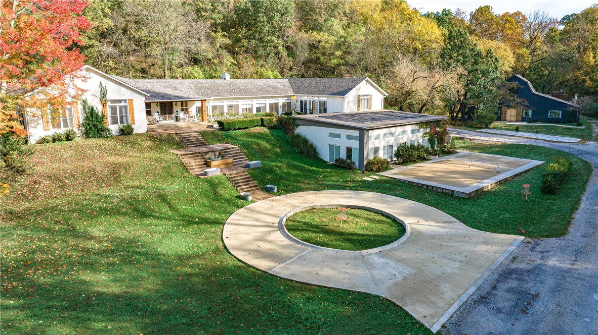 Discover Corvus Creek, a modern masterpiece on 18acres in Bentonville -- where luxury meets adventure. This 6854sqft estate blends farmhouse charm with HGTV-renovated elegance—featuring a main house (4654sqft, 5br/5ba, indoor pool, 4car garage) as well as a 100-yr-old barn (2200sqft, 2br/1ba) transformed by Dave & Jenny Marrs (Fixer to Fabulous) with gorgeously creative custom barnwood finishes. The main residence boasts a chef’s kitchen, massive dining room, two huge living rooms, 5bedrooms, and all one level! Ride out your door to adjacent Snowbird Trail mountain bike access, camp in glamping tents along a private gravel loop, or relax by the creek-side pergola and fire pit. Recent upgrades include a 2025 roof, stamped concrete patios, cedar accents, seamless gutters, and Thuja privacy screens. A rare blend of seclusion, recreation, and refined living—schedule your private tour today.