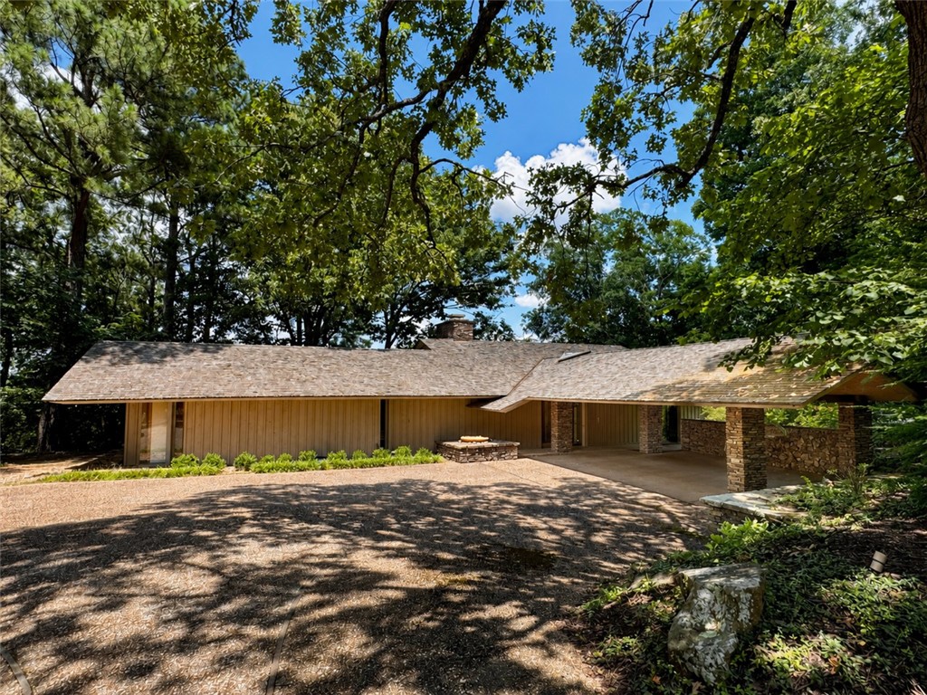 The best of Fayetteville! This Fay Jones-designed home sits on a nearly half-acre lot atop Mount Sequoyah. Original architecture has been beautifully preserved throughout and blends seamlessly with the surrounding landscape. This four-bedroom home features a sunken living room with a massive stone fireplace and balcony with winter views. The primary suite, study, and half bath are just off the living room. Opposite the entry is a spacious dining room with custom built-ins. The eat-in kitchen offers two stainless steel refrigerators, unique pantry sliders, double ovens, a cooktop, and a large peninsula. A cozy reading nook leads downstairs to a family room overlooking native stone patios and landscaped grounds. A wet bar and kitchenette make entertaining easy. Three additional bedrooms and two full baths complete the lower level. Heated and cooled workshop or extra storage located below balcony. See attached for more details on this amazing property.