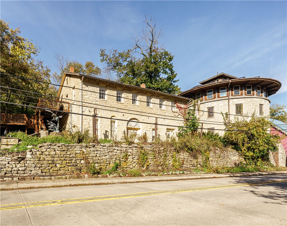 Historic lodging right across from the train station!  This gorgeous limestone structure was built by the Ozarka Water Bottling Co in 1895 and is now the Brownstone Inn.  Includes FIVE beautifully furnished, non-restricted short term rental suites, 6 parking spaces parking above and below, and a common dining/sitting area plus kitchen, all with independent central air.  A detached limestone carriage house may be used as storage, a garage, or developed into more lodging or retail.  A beautiful common-area deck overlooks the antique train cars.  Plenty of utility and storage space.  Financials available to qualified buyers.  The rentals are professionally managed by a company willing to continue services for a seamless transition.  State and Federal tax programs may offer up to a 45% tax credit on approved renovations.  NOTE:  This listing does not include the Round House, which is a separate property, and not for sale.