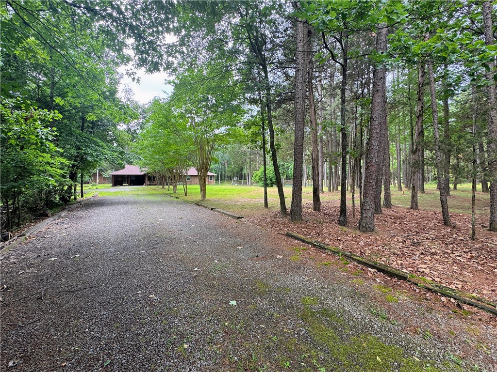 Welcome to your own little slice of peaceful country charm! Nestled on just under six beautiful acres and only minutes from town, this adorable 1,739 SF home is full of warmth, character, and space to truly enjoy life. Inside, you’ll love the super open layout featuring three spacious bedrooms, two full baths, and a beautifully remodeled kitchen that flows effortlessly into the living and dining areas. The oversized pantry is the cherry on top! Step outside and prepare to fall in love with the generous stocked pond filled with catfish, brim, and bass, complete with sweet little sitting spots scattered around the water for fishing, relaxing, or soaking in the peaceful views. Covered front and back porches make the perfect place for morning coffee or quiet evenings, while the spacious 400 SF shop with lean-to gives plenty of room for hobbies, storage, or outdoor toys. Cozy, inviting, and absolutely picture-perfect—this one feels like home the moment you arrive!