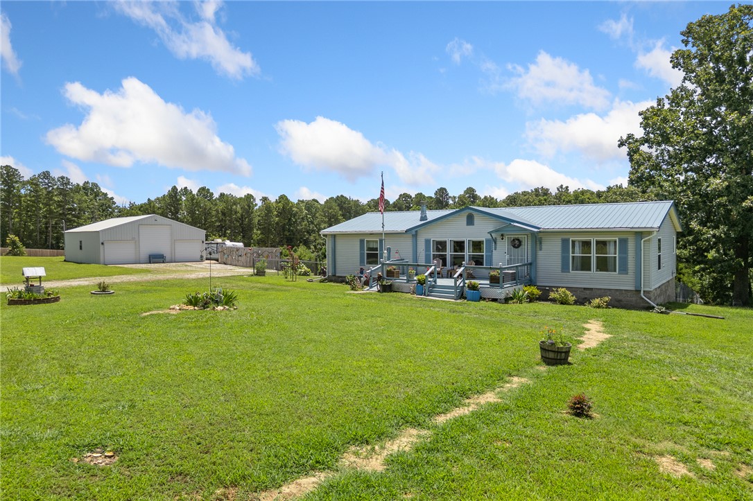 This one is a gem!! 4.92 m/l acres, 1,680 sqft 3 bedroom 2 bathroom beautiful home with a metal roof, 1,500 sqft shop building with electric and 3 garage doors, one being an RV door!  This very well maintained property shows pride of ownership from the moment you pull up!  If you're looking for a spacious home on nearly 5 acres with a 1500 sqft shop building and an above ground pool, this is the one!  Bergman school district is a bonus too.  The home has an open floor plan, no carpet in the home - all tile and wood flooring, a wood burning fireplace and a huge covered back deck to enjoy views of your land and entertaining your friends and family!  The primary suite is very large in size with a walk-in closet and ensuite bath that you will love with double vanity, step in shower and soaker tub!  Less than a mile down a good dirt road, this property gives you the best of country living, privacy and peace while still being close to all this area has to offer including Bull Shoals Lake, Harrison and Branson!