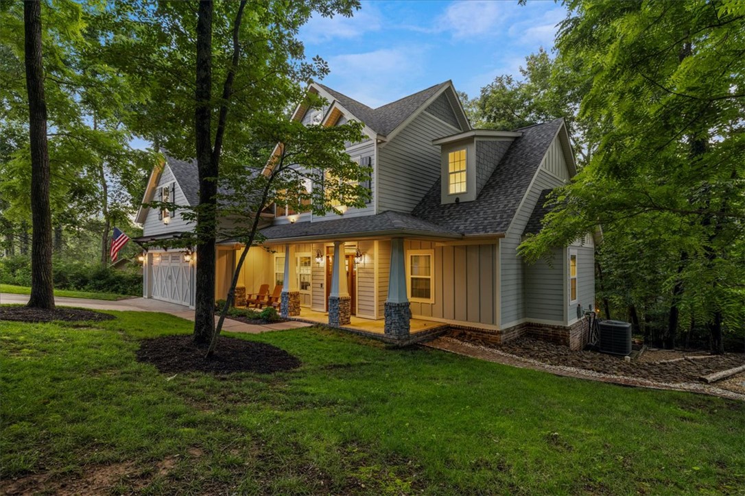 Welcome to The Hill House, where luxury living meets one of the most coveted lifestyle locations in Bella Vista. Nestled on a rare .66-acre city sewer lot backing directly to the Blowing Springs trail system, this custom Craftsman offers a level of connection to nature and recreation that few properties can match. Step from your backyard onto miles of singletrack trails and the  Greenway, then stroll to the Gear Garden for food, drinks, and live music that can be enjoyed from the comfort of your own patio. Inside, the 2,810-square-foot home blends warmth and sophistication with vaulted beam ceilings, striking brick archways, a wood-burning fireplace, and an open, inviting floor plan designed for gathering and entertaining. The spacious kitchen flows seamlessly into the living and dining areas, while the luxurious primary suite offers a spa-like retreat. Outdoor living is equally impressive with a dreamy covered patio, outdoor fireplace, and peaceful wooded surroundings. Welcome Home!
