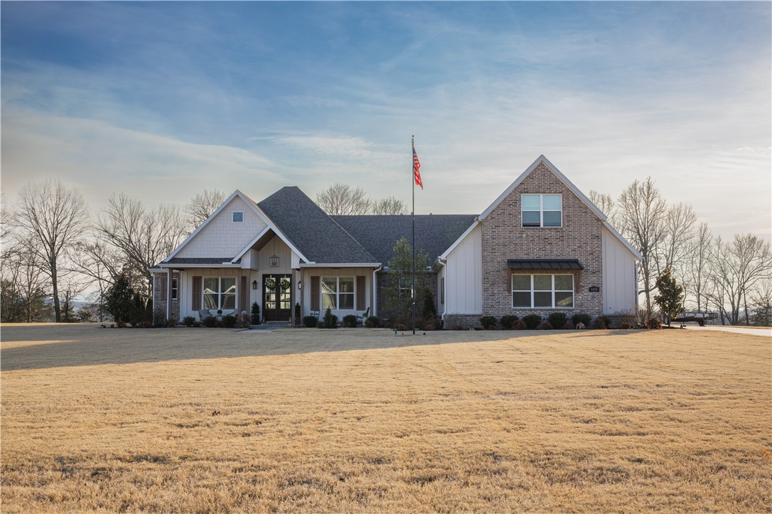 Serene 2.1-acre setting in Riverside Estates with backyard views overlooking the White River & Boston Mountains. Approx. 3,900 sq ft custom home built 2021 showcasing exceptional craftsmanship, serious attention to detail & thoughtful upgrades. Main level features majority of living space with all bedrooms on main floor for comfort & convenience. Upstairs offers spacious bonus room/den & full bath. Gourmet kitchen is designed for function & style with suede quartz countertops, double ovens, upgraded appliances, large pantry & wine feature. Engineered wood flooring & soaring 10-ft ceilings enhance home, while great room highlights beamed cathedral ceilings & beautiful floor-to-ceiling fireplace all overlooking landscaped backyard. Patio with electric screen enclosure, fireplace & access to saltwater pool. Distinctive safe room with fire-rated, keypad-protected entry, reinforced 8-inch concrete walls & ceiling and ventilation dampers. Four-car garage, half heated/cooled for shop use. Detailed amenity list available.