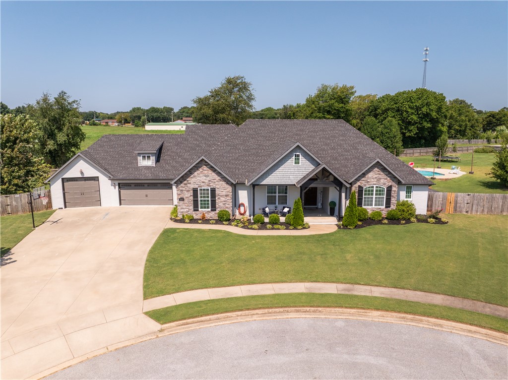 Tucked into a quiet cul-de-sac in Twin Falls neighborhood, this Craftsman sits on nearly an acre and offers 5 bedrooms, 4.5 baths, and 3,529sf of living space.The split floor plan centers on a cathedral-ceiling living room with gas fireplace, opening to an eat-in kitchen with granite counters.The main-level hosts a primary suite, 3 additional bedrooms and an office, while an upstairs suite includes a bedroom, full bath, bonus room, and a ladder-access playhouse nook adds flexible space for guests or hobbies. Step outside to a covered patio, heated saltwater pool, the hot tub conveys, too. An oversized 3car garage includes a storm shelter and a drivethru third bay with workshop and double gates. Additional highlights: central vacuum, whole-home sound wiring, soffit electrical, wood privacy fencing, and professional grade gas range, double door refrigerator, washer, and dryer that convey. Minutes from Fayetteville, the University of Arkansas, and Hwy49, with Farmington's smalltown charm and top schools close to home.