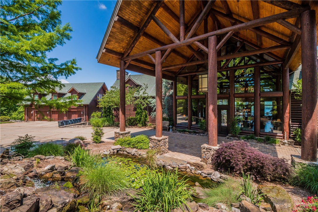 Step into this luxurious, Greers Ferry Lake retreat, artistically crafted log home, and nourish your mind, body and spirit. Offering endless possibilities, this fully furnished estate features a gourmet kitchen, a 40’ vaulted wood-beam great room with a stacked stone fireplace, open dining room, a recreation room with wet bar, an exercise room, 12 bedrooms – each with their own bath or access to shared bath and all with private views of the lake– plus a detached 3-car garage area with 2 separate apartments. This home boasts exceptional access to outdoor recreation, with peaceful panoramic views that will make you feel embraced by nature. Privacy is an understatement when it comes to this 22,000 square-foot lakefront estate. The spacious living areas inside combine with the 5.82 acres outside to form the ultimate secluded corporate retreat or vacation home.  Home comes fully furnished.
