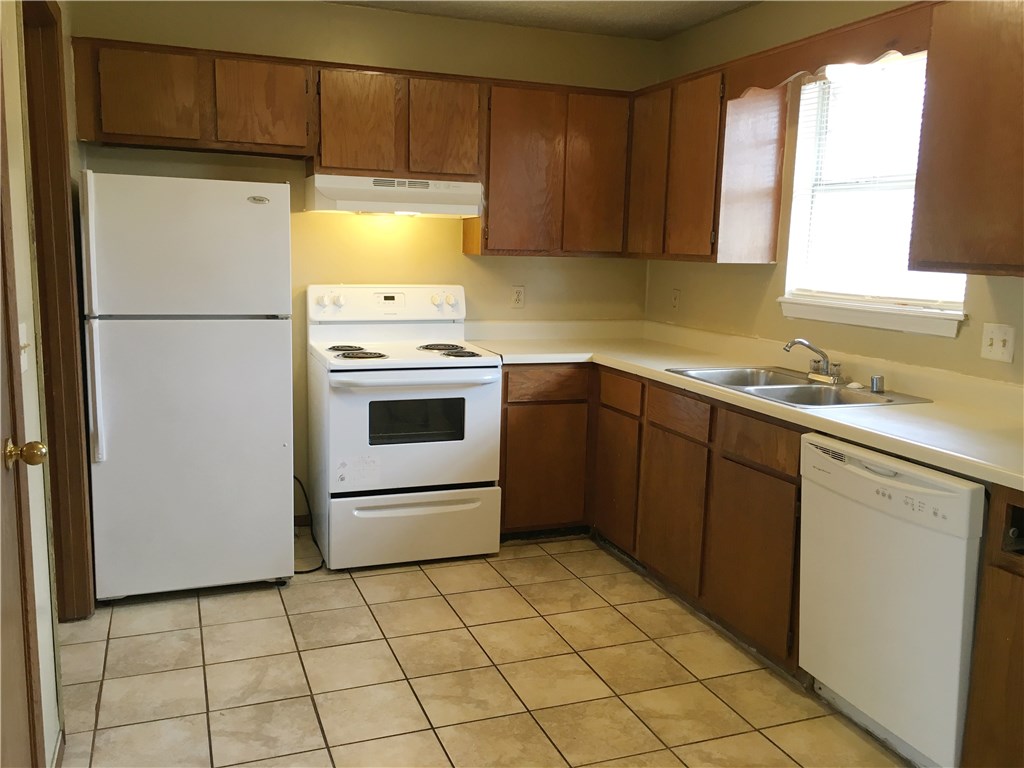 2 bedroom, 1 bath duplex with one car garage and fenced back yard. Kitchen overlooks eating area with refrigerator, stove, and dishwasher. Laundry room has washer/dryer hookups. Shower/tub combo in bathroom. Ceramic tile throughout unit. Tenant pays electric, gas, water/trash. Corner lot. Note: Interior pictures are of similar unit in same building.