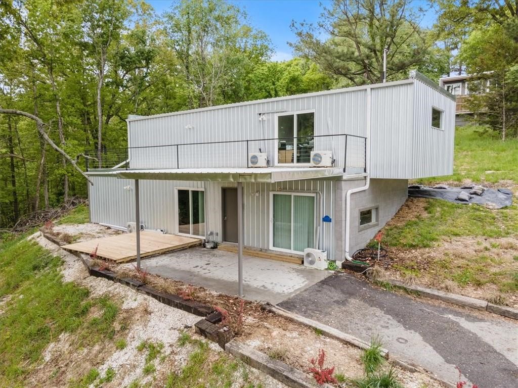 Welcome to your modern retreat on 1.28 acres in the Wedington Woods area. This modern two story home sits atop a gently rising hill surrounded by trees, views, and serenity.  It has three bedrooms and three baths with two primary suites on each level. The home has luxury vinyl plank flooring, granite counters and led lighting.  There is also a massive walk in closet in the upper primary suite.  The home comes with a private deck and patio perfect for sunsets and morning coffee. This home is spot on for buyers that seek privacy and style, home hackers who need multiple suites, and nature lovers who want land without sacrificing modern design.