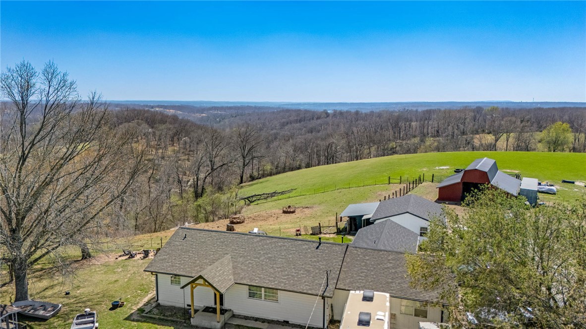 Perched atop one of the highest elevations in NWA, Coose Hollow Ranch (CHR) spans 54 extraordinary acres-offering a rare blend of privacy, scale, & commanding panoramic views just minutes from Rogers & only 12 minutes from the new Walmart Home Office. From its elevated ridgeline, the property captures sweeping, million-dollar views across the Ozarks to the Boston Mountains beyond Fayetteville- this is not simply land-it is a legacy-caliber holding. 
A thoughtful mix of rolling pasture & mature Ozark hardwoods, the property is both highly functional & visually striking, offering flexibility for a private luxury estate or multi-generational compound, a premier view-lot development opportunity, or continuation as a working hobby farm. Improvements include a 3 bed/2 bath farmhouse, a large barn, & established corrals, supporting cattle & sheep operations. This is a once-in-a-generation opportunity to own contiguous acreage in desirable NWA!
Call for offers: Please submit all offers by May 15, 2026.