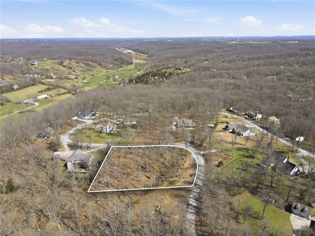 Build your custom home on this beautiful wooded lot tucked into an established setting with a peaceful, private feel. The property offers a gently sloping topography—ideal for a walkout basement design—and is surrounded by mature trees. Water tap onsite and electric available, giving you a head start on your build.  Minutes from Bella Vista trails and Hwy 71, offering both convenience and access to outdoor recreation.  Multiple house plans available upon request, thoughtfully designed for the lot. Buyer can also be connected with a custom builder if desired.